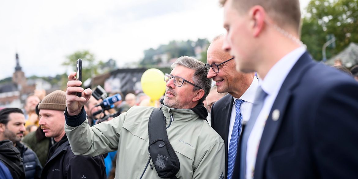 Bürger in Saarbrücken macht ein Selfie mit dem Kanzler.